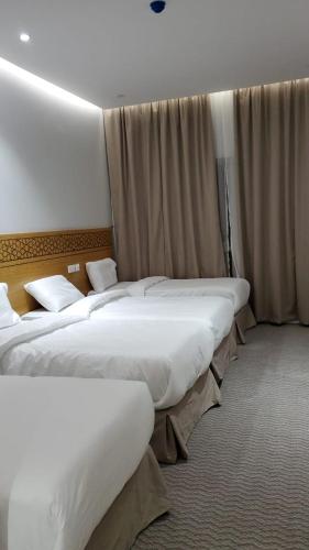 a row of three beds in a hotel room at فندق سدرة المحبس in Al Khansāk