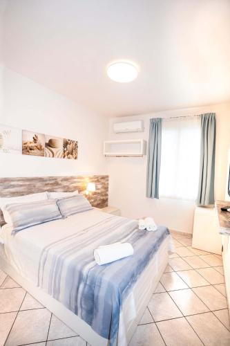 a bedroom with a large bed with blue and white sheets at Taormina Beach House in Mazzeo