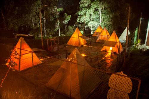 un gruppo di tende viene illuminato di notte di Glamping termales La Calera a La Calera