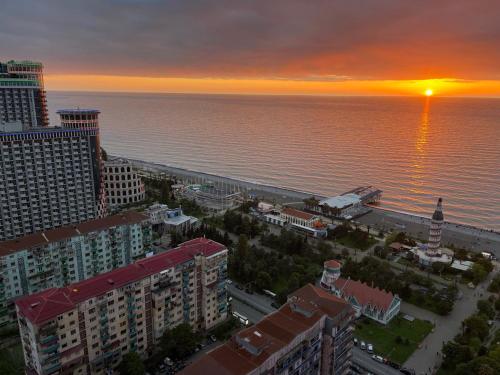 una vista aérea de la ciudad y del océano al atardecer en Orbi city Panorama towers, en Batumi