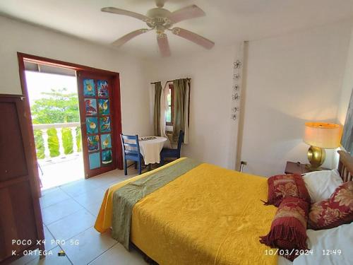 een slaapkamer met een bed en een plafondventilator bij Hotel Villa Ordonez in Pochomil