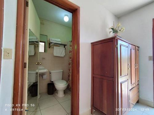 a bathroom with a toilet and a cabinet in it at Hotel Villa Ordonez in Pochomil