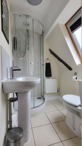 Un baño blanco con lavabo y ducha. en Marine hotel, en Great Yarmouth
