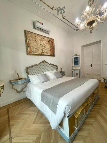a bedroom with a large bed and a chandelier at Stile Libero Guest House in Turin