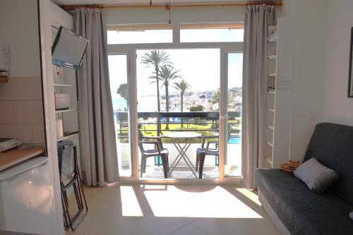ein Wohnzimmer mit einem Sofa und einem Balkon mit einem Tisch in der Unterkunft Castillo de Santa Clara in Torremolinos