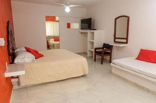 a hotel room with two beds and a mirror at Royal Pacífico Manzanillo in Manzanillo