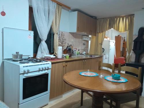 a kitchen with a table and a white stove top oven at Dolores in Tešanj