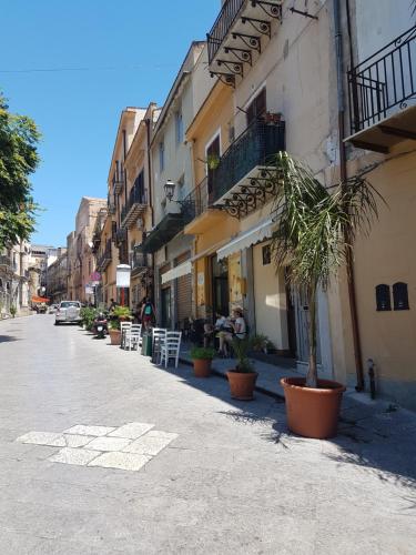 une rue avec des chaises et des plantes sur le côté d'un bâtiment dans l'établissement A casa da Mari, à Palerme