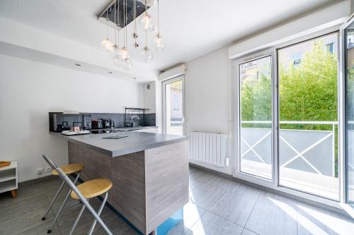 - une cuisine avec un comptoir, des chaises et des fenêtres dans l'établissement Le calme à Nissa la Bella, à Nice