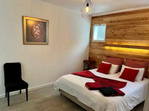 Un dormitorio con una cama con almohadas rojas y una silla en Caloura Fire Accommodation, en Lagoa