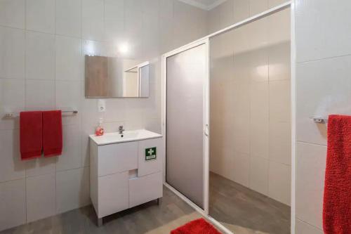 baño con lavabo blanco y toalla roja en Caloura Fire Accommodation, en Lagoa