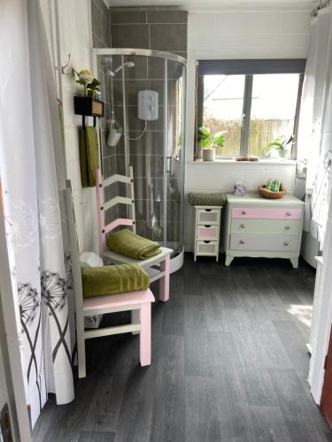 a bathroom with a shower and a bench and a sink at Tyluna Cornish Glamping Cabin in Praze an Beeble