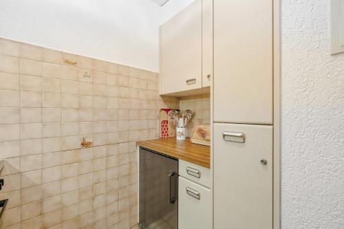 a small kitchen with white cabinets and a counter at Duplex cosy aux bains de Saillon in Saillon