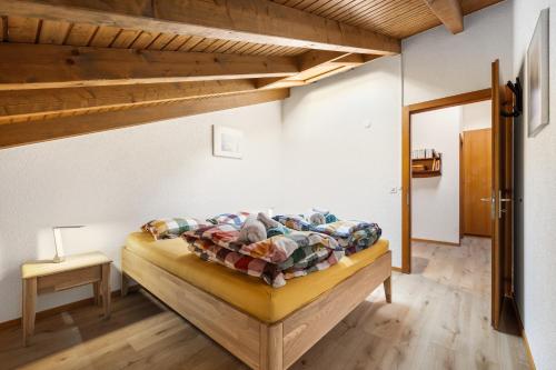 a bedroom with a bed in a room with wooden ceilings at Duplex cosy aux bains de Saillon in Saillon