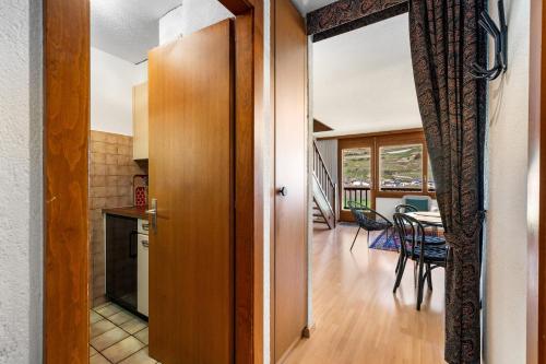 a kitchen and a dining room with a table at Duplex cosy aux bains de Saillon in Saillon