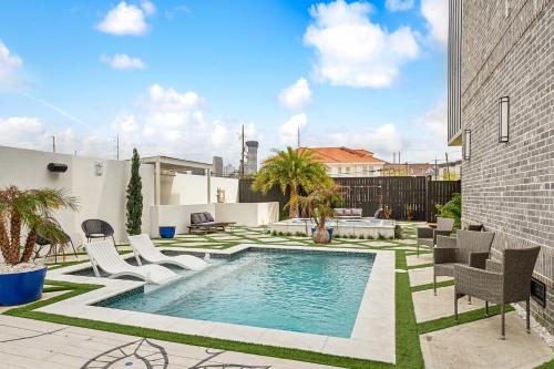 a backyard with a swimming pool and chairs at Celeste Rooftop Villa in New Orleans