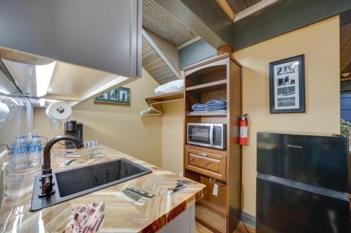 a kitchen with a sink and a refrigerator at Central Texarkana Studio Rental with Railroad Views! in Texarkana