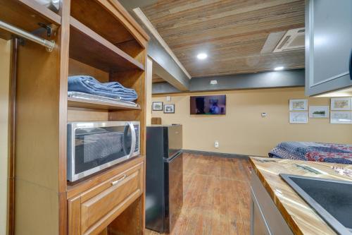 a kitchen with a sink and a microwave at Central Texarkana Studio Rental with Railroad Views! in Texarkana