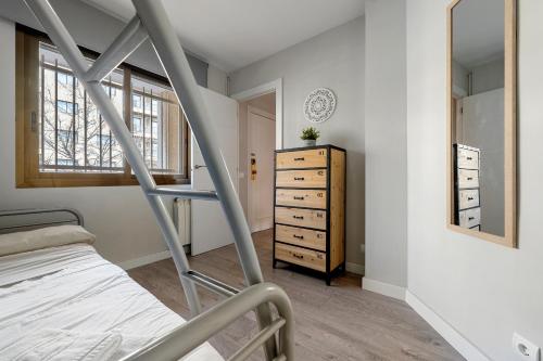 a bedroom with a bunk bed and a dresser at Precioso apto, con piscina en puerto de Cambrils, wifi y parking incluido in Cambrils