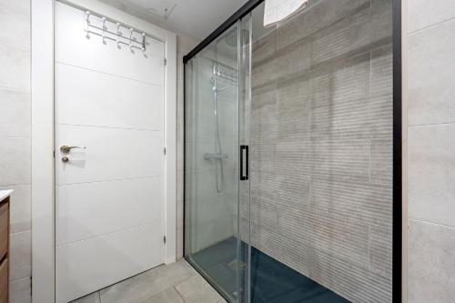 a walk in shower with a glass door at Precioso apto, con piscina en puerto de Cambrils, wifi y parking incluido in Cambrils