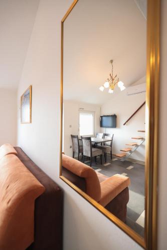 a mirror reflecting a living room with a dining room at Villa Eni in Bibinje