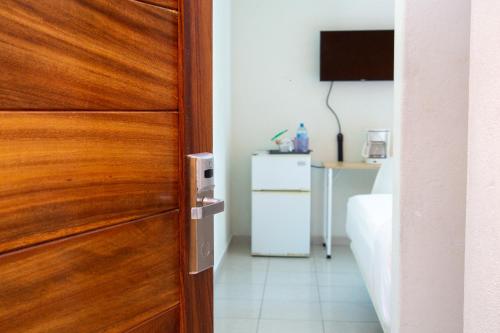 a wooden door in a room with a television at Fabuloso Hotel Las Vegas in Zihuatanejo