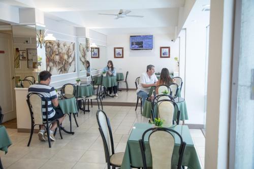 a group of people sitting at tables in a restaurant at Hotel Select in Mar del Plata