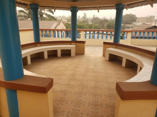 balkon z 2 ławkami i niebieską poręczą w obiekcie Maison d'hôte avec paillote w mieście Kpalimé