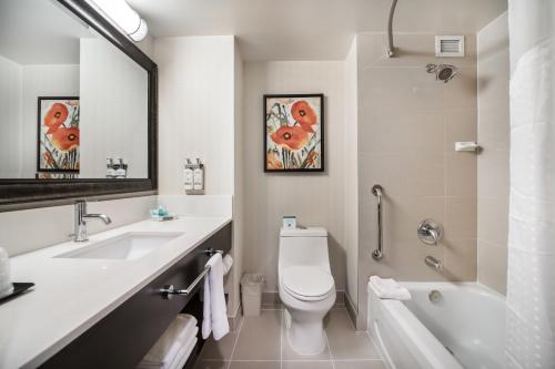 a bathroom with a sink and a toilet and a tub at Holiday Inn Vancouver-Centre Broadway by IHG in Vancouver