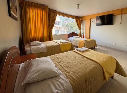 a hotel room with three beds and a window at Illari Wari l - Hotel Sauna in Ayacucho