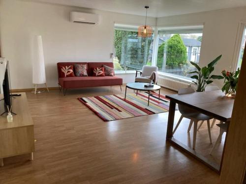 sala de estar con sofá rojo y mesa en Neeravert, en Londerzeel