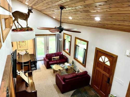 a living room with couches and a ceiling fan at Cedar Cabin Near Silverwood in Spirit Lake