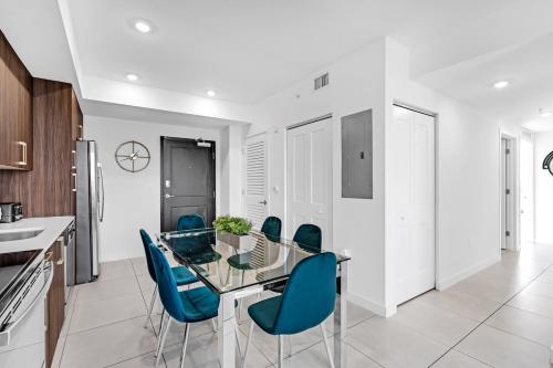 een keuken met een glazen tafel en blauwe stoelen bij Chic 3 Bed Retreat Mins Brickell With Free Parking in Miami