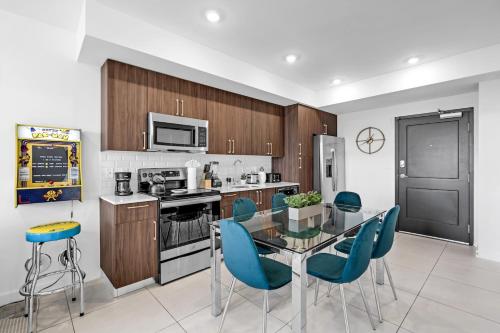 een keuken met een glazen tafel en blauwe stoelen bij Chic 3 Bed Retreat Mins Brickell With Free Parking in Miami