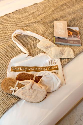 a pair of shoes and a book on a bed at Aegean Stories pelagos suites in Avlákia
