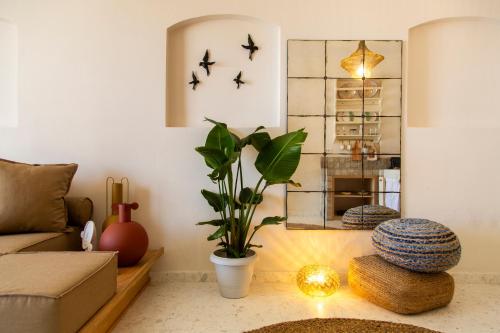a living room with a couch and a plant at Aegean Stories pelagos suites in Avlákia