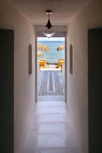 a hallway with a view of the beach from a house at Aegean Stories pelagos suites in Avlákia
