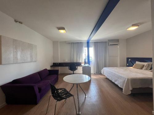 um quarto com uma cama, um sofá e uma mesa em MH 30904 - Aconchegante Studio Alphaville WF/AC em Barueri