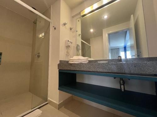 uma casa de banho com um lavatório e um chuveiro em MH 30904 - Aconchegante Studio Alphaville WF/AC em Barueri
