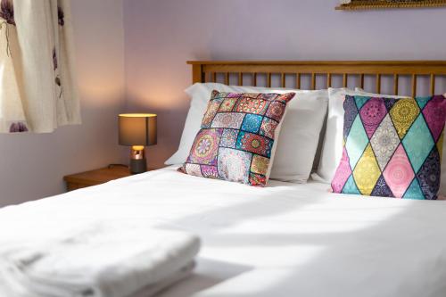 a bed with white sheets and pillows and a lamp at Oak House in Mid Wales By Seren Short Stays in Machynlleth