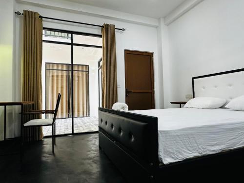 a bedroom with a large bed and a chair at Large 4 Bedroom Spacious Apartment in Nugegoda, Colombo in Nugegoda