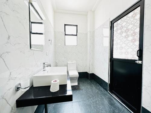 a white bathroom with a sink and a toilet at Large 4 Bedroom Spacious Apartment in Nugegoda, Colombo in Nugegoda