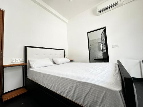 a bedroom with a white bed with a mirror at Large 4 Bedroom Spacious Apartment in Nugegoda, Colombo in Nugegoda