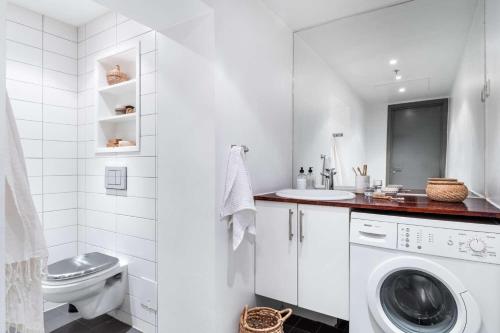 baño blanco con lavadora y lavamanos en Entire rental unit in Grünerløkka, Norway en Oslo
