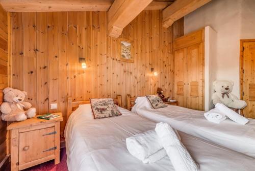 two beds in a room with two teddy bears at Chalet Gypaete - Chalets pour 14 Personnes 881 in Tignes