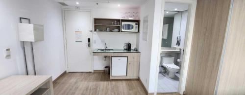 a small white kitchen with a sink and a toilet at Suíte 5 estrelas Hotel Av Ibirapuera 2534 Moema - 1 in Sao Paulo