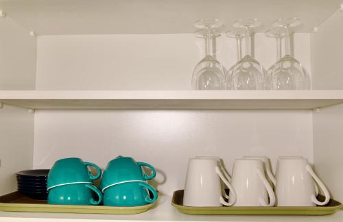 a shelf with plates and cups and glasses on it at Mary St House 3B in Dublin