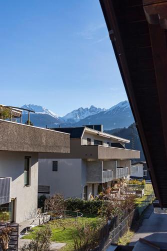 a view of a building with mountains in the background at Privatzimmeroase Felicitas exklusive Zimmer in Zirl
