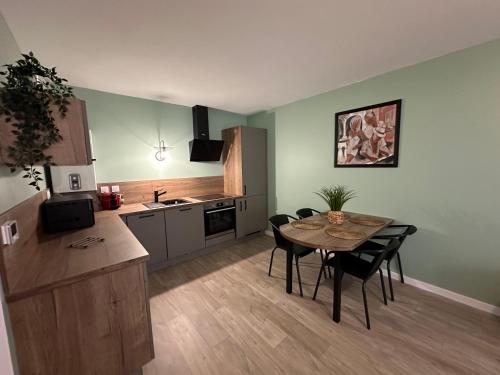 une cuisine et une salle à manger avec une table et des chaises dans l'établissement L'émeraude, à Cancale