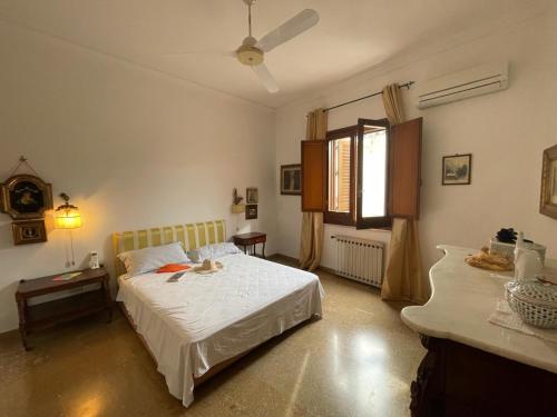 una camera con un letto bianco e una finestra di Dimora Teodolinda Centro Storico Marsala a Marsala